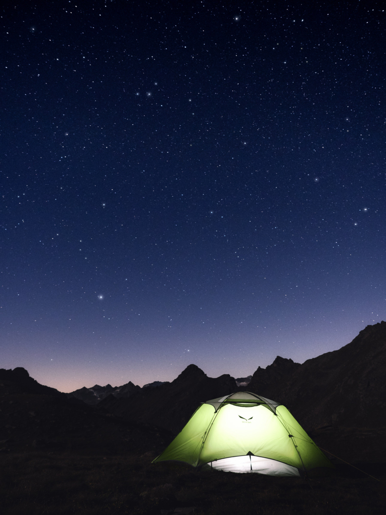 Una tenda illuminata sotto un mare di stelle nello scatto di Gianni Zanella