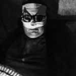 Ando Gilardi ( 1921-2012 ) con il volto bendato per ustioni riportate in un incidente domestico