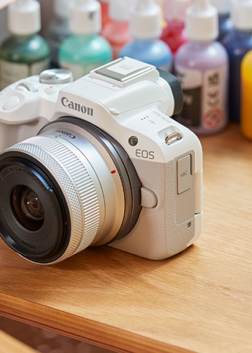 Canon Eos R50 mirrorless bianca esposta su un tavolo