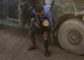 Ivor Prickett, End of the Caliphate, Un uomo collassa fuori da un veicolo blindato presso la postazione di pronto soccorso di Mosul est, stringendo il corpo del fratello minore ucciso qualche momento prima da un attacco di mortaio dell’ISIS, Mosul, Iraq, 2016, Courtesy and © Ivor Prickett