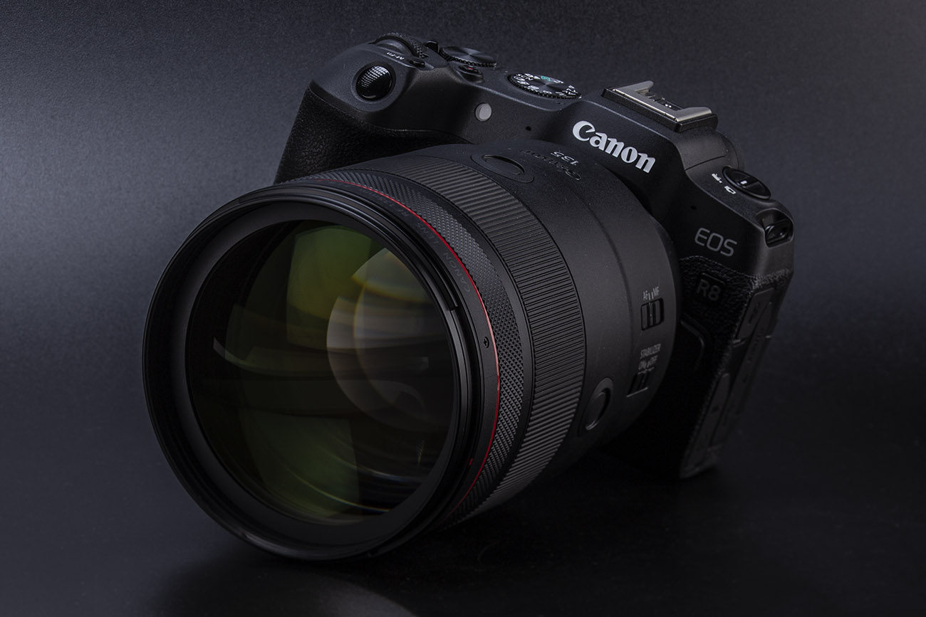 Canon Eos R8 con teleobiettivo RF 135mm f/1,8 su sfondo nero