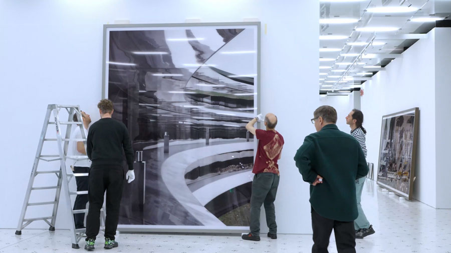 Andreas Gursky, in primo piano sulla destra, assiste al montaggio di "Apple" sulle pareti della Fondazione MAST.