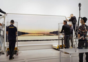 Una squadra lavora all'installazione di "Salinas" sulla parete di una delle prime sale del percorso della mostra.