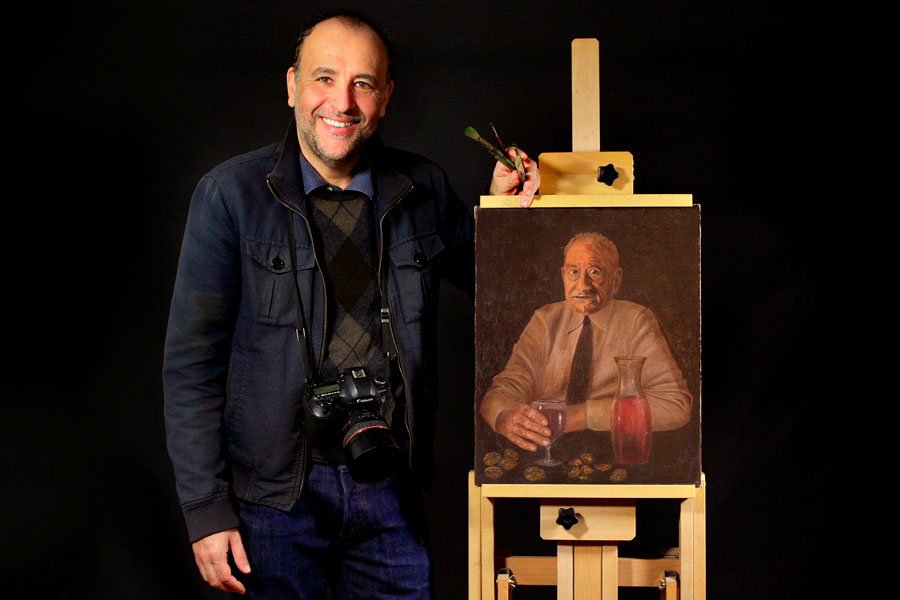 Danilo Coluccio in studio con un suo dipinto a olio