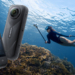 Insta360 X5 fronte/retro su sfondo subacqueo
