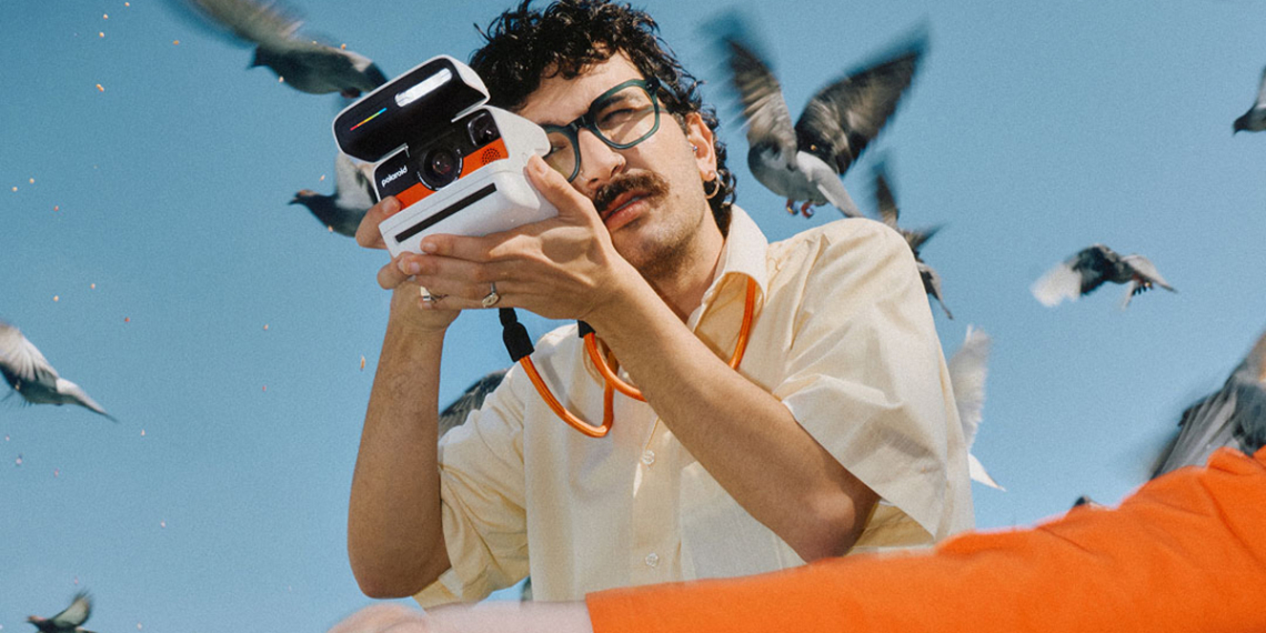 Polaroid Flip in mano a uomo con i baffi