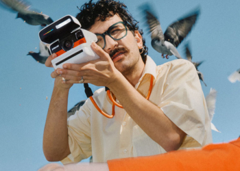 Polaroid Flip in mano a uomo con i baffi