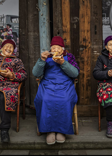 La fotografa cinese Xiaoling Li è stata incoronata Vincitrice Assoluta dei World Food Photography Awards, sponsorizzati da Bimi, e ha ricevuto un premio di 5.000 sterline per una commovente immagine che ritrae anziani vicini di casa riuniti a condividere storie mentre gustano involtini primavera del Sichuan.