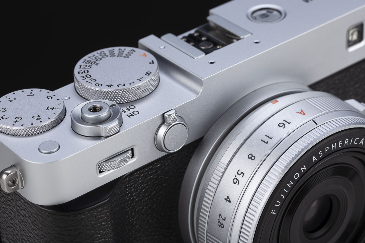La particolarità di tutte le Fujifilm con sensore da 40 megapixel, e quindi anche della X-E5, è quella di sfruttare l’alta densità di pixel per simulare un moltiplicatore di focale digitale su due livelli. Il primo livello applica un ingrandimento di 1,4x, riducendo la risoluzione da 7728x5152 a circa 5472x3648 pixel. Il secondo livello prevede un ingrandimento 2x, che abbassa la risoluzione a circa 3864x2592 pixel. Le connessioni della X-E5 sono essenziali, con la presa per il microfono affiancata a quella USB-C/cuffie e alla HDMI di taglia piccola. Il tasto per attivare il Bluetooth è, curiosamente, ospitato nel fondello.