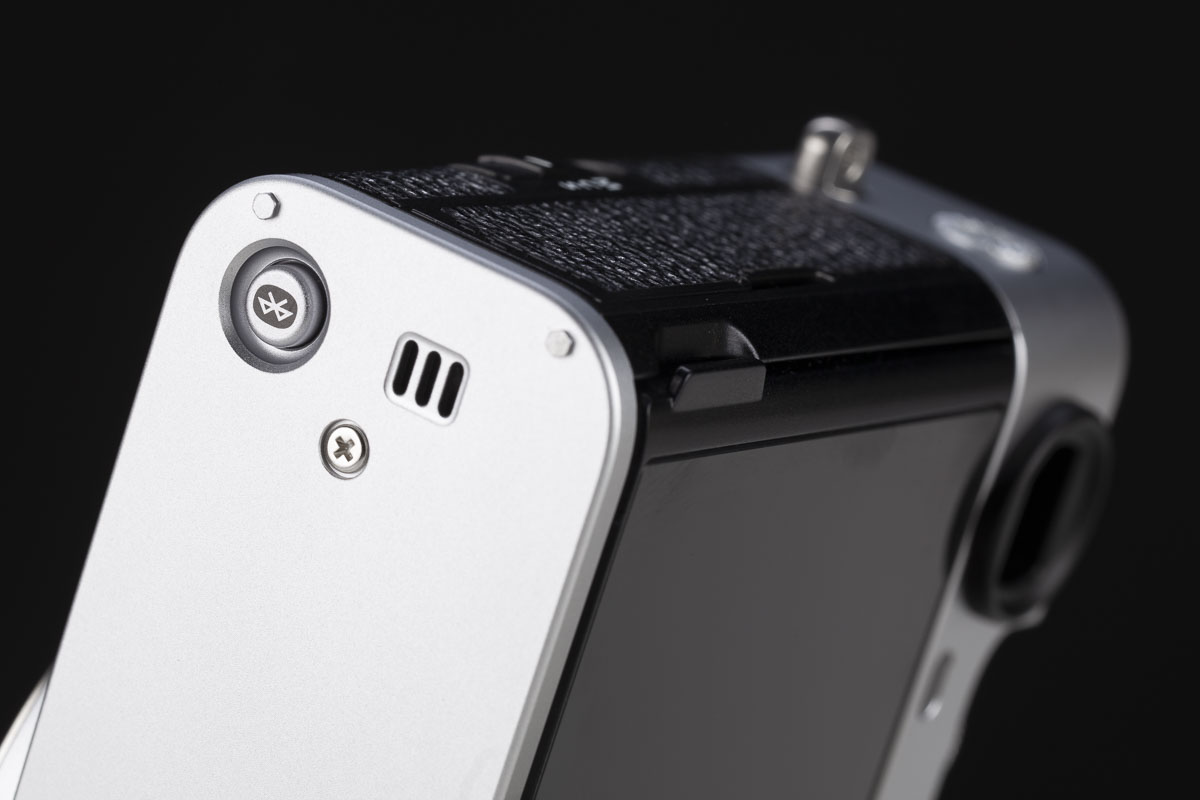 La particolarità di tutte le Fujifilm con sensore da 40 megapixel, e quindi anche della X-E5, è quella di sfruttare l’alta densità di pixel per simulare un moltiplicatore di focale digitale su due livelli. Il primo livello applica un ingrandimento di 1,4x, riducendo la risoluzione da 7728x5152 a circa 5472x3648 pixel. Il secondo livello prevede un ingrandimento 2x, che abbassa la risoluzione a circa 3864x2592 pixel. Le connessioni della X-E5 sono essenziali, con la presa per il microfono affiancata a quella USB-C/cuffie e alla HDMI di taglia piccola. Il tasto per attivare il Bluetooth è, curiosamente, ospitato nel fondello.