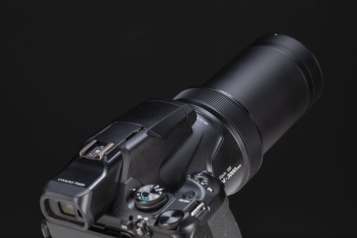La Nikon P1100 fotografata al minimo del suo ingombro, ossia alla focale di 24mm, e con l'ottica al massimo della sua estensione (3000mm). Nel complesso, lo spazio occupato nello zaino corrisponde grossomodo a quello di una mirrorless di taglia grande equipaggiata con un'ottica tuttofare.