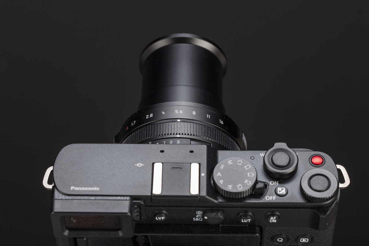 Lo zoom Leica DC Vario-Summilux integra la ghiera del diaframma e l'anello per la messa a fuoco manuale. L'obiettivo è telescopico: collassato riduce significativamente le dimensioni della fotocamera, mentre all'escursione massima di 75mm il barilotto sporge di circa 5cm dal corpo.