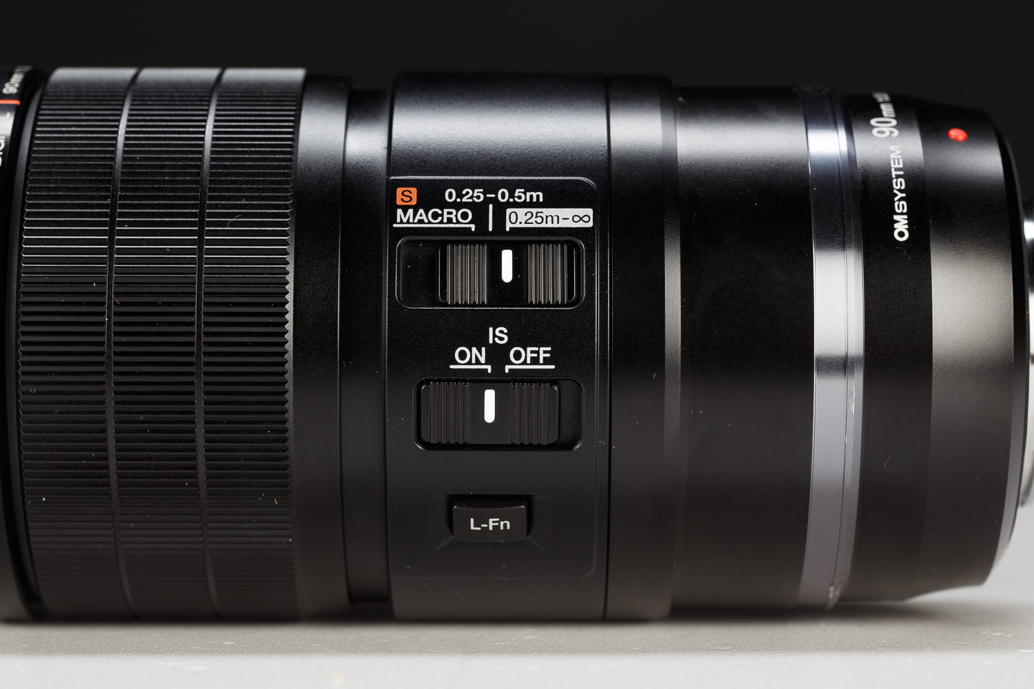 La ghiera di messa a fuoco presenta il meccanismo Manual Focus Clutch: scorrendo assialmente verso il fotografo, si disinserisce istantaneamente il motore AF per passare al controllo manuale, con scala graduata incisa fisicamente sul barilotto per preimpostare la distanza di lavoro. Sul fianco sinistro del 90mm trovano posto tre controlli: il limitatore di messa a fuoco a tre posizioni, l'interruttore on/off per la stabilizzazione ottica (IS) e il pulsante funzione L-Fn personalizzabile.
Da notare che la posizione S Macro, che porta il rapporto di riproduzione a 2:1, agisce sulla posizione delle lenti, di fatto modificando lo schema ottico per ottimizzare le prestazioni.